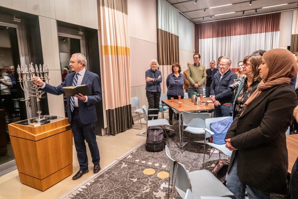 Rabbijn Menno ten Brink van de Liberaal Joodse Gemeente in Amsterdam ontsteekt het licht in de Chanoekia.Beeld Joris van Gennip